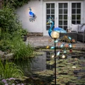 Ozdobna lampa solarna paw na ścianę oraz stojąca wersja do ogrodu przy oczku wodnym, tworzą spójną i efektowną aranżację przestrzeni wokół domu.