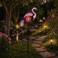 Ozdobna lampa solarna w kształcie flaminga na paliku, z efektowną kulą LED, idealna do wyeksponowania w ogrodzie, na trawniku lub wzdłuż ścieżki.