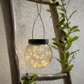 Wisząca lampa solarna LED w formie szklanej kuli zawieszona na drewnianej drabince, dekoracyjne oświetlenie zewnętrzne z ciepłym światłem do ogrodu, tarasu i balkonu.