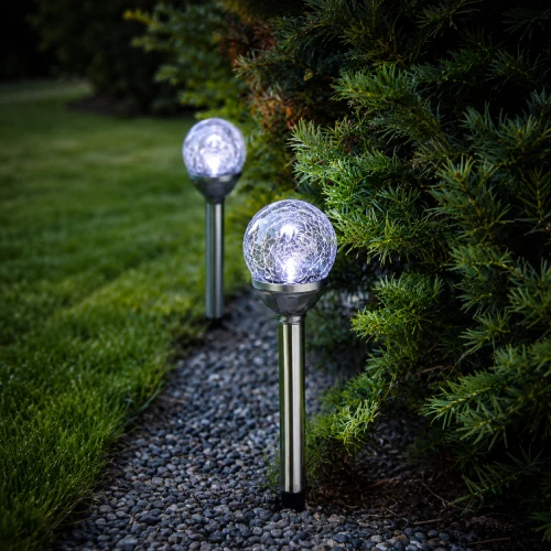 Dwie solarne lampy ogrodowe LED z kulami o efekcie spękanego szkła emitujące chłodne białe światło, dekoracyjne oświetlenie ścieżki ogrodowej i rabat.