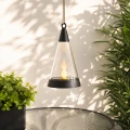 Wiszący lampion solarny LED z realistycznym efektem płomienia zawieszony nad stołem na tarasie, idealny do dekoracji balkonu, patio i przestrzeni ogrodowej.