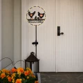 Solarna dekoracja ogrodowa LED z napisem Welcome i motywem kur ustawiona przy wejściu do domu.