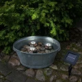 Lampy solarne LED umieszczone w wodzie zasilane panelem słonecznym ustawionym obok zbiornika.
