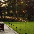Kilka solarnych dekoracji ogrodowych FIREWORK® rozmieszczonych wzdłuż ścieżki i trawnika. Świecące punkty LED tworzą efekt rozbłysków sztucznych ogni po zmroku.