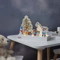 Scenka LED z Pippi Pończoszanką ustawiona na dziecięcym stoliku. Wśród postaci widać choinkę, konia, bałwanka, Pana Nilssona i prezenty, a ciepłe światło tworzy świąteczny nastrój.