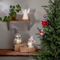 Świąteczna aranżacja z dwiema podświetlanymi zawieszkami w formie myszek w kubkach, zawieszonymi na choince obok innych zimowych dekoracji.