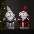 Dwie świąteczne figurki LED Mikołaje w szarym i czerwonym stroju, podświetlane ciepłym światłem, ustawione obok siebie i tworzące ciepły, domowy nastrój bożonarodzeniowy.