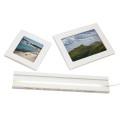 Zestaw ramki LED FUGA w częściach – biała podstawa z podświetleniem i dwa panele ze zdjęciami krajobrazów.