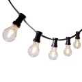 Girlanda ogrodowa z czarnym przewodem i żarówkami LED A60 0,5W 2100K z serii Soft Glow, zawieszona w łuku. Żarówki w przezroczystym szkle emitują dekoracyjne, ciepłe światło z widocznymI żarnikami.
