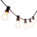 Girlanda ogrodowa z czarnym przewodem i żarówkami LED A60 2,3W 2100K z serii Soft Glow, zawieszona w łuku. Żarówki w przezroczystym szkle emitują miękkie, ciepłe światło z widocznymI żarnikami.