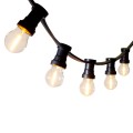 Girlanda ogrodowa z czarnym przewodem i żarówkami LED G45 0,8W 2100K z serii Soft Glow, zawieszona w łuku. Żarówki w przezroczystym szkle emitują dekoracyjne, ciepłe światło z widocznymI żarnikami.
