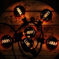 Girlanda świetlna z żarówkami LED Filament G125 ułożonymi na drewnianym tle, bardzo ciepłe światło tworzące nastrojowy klimat.