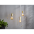 Lampa wisząca SHAPE z cylindryczną złotą oprawką i pionową owalną ramą wokół źródła światła.