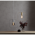 Lampa wisząca SHAPE z mosiężną oprawką E27 i szeroką kwadratową ramą o zaokrąglonych narożnikach.