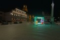 Dekoracja świetlna LED „Wesołych Świąt” z motywami wielkanocnymi, zającem w koszyku, kurczakiem i kolorowymi jajkami, instalacja do sesji zdjęciowych na rynku miasta.