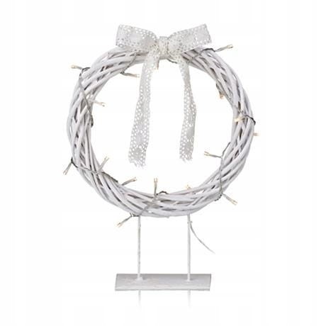 Biały wianek dekoracyjny LED na stojaku z ozdobną koronkową kokardą, oplatany ciepłymi światełkami, elegancka świąteczna ozdoba stołu lub komody.