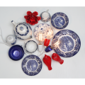 Kompozycja porcelany w biało-niebieski wzór z żarówkami LED filament E27 i czerwonymi dekoracjami, widok z góry.