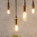 Aranżacja dekoracyjnych żarówek LED filament w mosiężnych oprawkach wiszących na przewodach. Żarówki retro emitujące ciepłe światło tworzą przytulny klimat wnętrza.