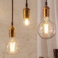 Aranżacja dekoracyjnych żarówek LED filament w mosiężnych oprawkach wiszących na przewodach. Ciepłe światło żarówek tworzy przytulny klimat wnętrza w stylu vintage.