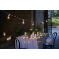 Łańcuch LED z mlecznymi kulkami wykorzystany jako dekoracja stołu i przestrzeni zewnętrznej, nastrojowe oświetlenie wieczorne.