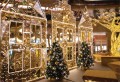 Domek 2D LED w miejskiej aranżacji z choinkami i iluminacjami, tworzący efektowną dekorację przestrzeni publicznych i galerii handlowych.