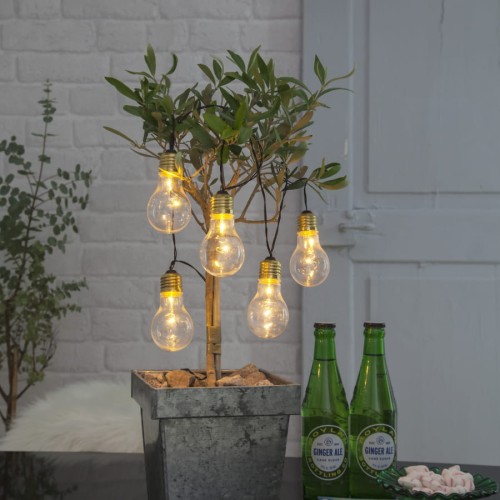 Girlanda LED GLOW z pięcioma przezroczystymi żarówkami dekoracyjnymi zawieszona na donicy z rośliną, ciepłe światło mikro diod LED tworzące przytulny klimat we wnętrzu.