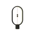 Czarna lampa HENG Balance Ellipse o eliptycznym kształcie z magnetycznym elementem umieszczonym wewnątrz ramy.