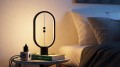 Lampa stołowa LED HENG Balance Ellipse z czarną ramą i dekoracyjnym ciepłym podświetleniem.