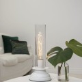 Lampa stołowa z wysokim szklanym kloszem i żarówką LED E27 T30 spiral filament w nowoczesnym wnętrzu.