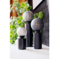 Minimalistyczna lampa TUB z wysoką czarną podstawą w kształcie cylindra i dekoracyjną żarówką.