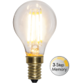 Dekoracyjna żarówka LED filament w kształcie A60 z małym gwintem E14 i funkcją 3-Step Memory. Przezroczysta bańka z czterema filamentami LED emitującymi ciepłe światło do lamp dekoracyjnych i świeczników.