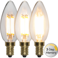 Zestaw trzech dekoracyjnych żarówek LED filament E14 pokazujący trzy poziomy jasności światła dzięki funkcji 3-Step Memory. Żarówki w kształcie świeczki emitują ciepłe światło.