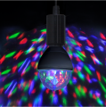 Żarówka LED disco w oprawce sufitowej podczas pracy, kolorowe refleksy RGB rozproszone na ścianie, dynamiczny efekt świetlny.