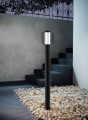 Czarna lampa ogrodowa RAVELLO z wysoką podstawą i zaokrąglonym kloszem o ażurowej konstrukcji.