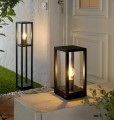 Czarna lampa CASCINETTA o geometrycznej, otwartej formie z widocznym źródłem światła.