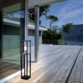 Lampa ogrodowa stojąca CASCINETTA z wysoką czarną konstrukcją i przeszkloną oprawą w górnej części.