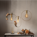 Lampa wisząca SHAPE z mosiężną oprawką E27 i szeroką kwadratową ramą o zaokrąglonych narożnikach.