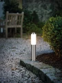 Lampa ogrodowa HELSINKI z metaliczną podstawą, cylindrycznym kloszem i płaskim zwieńczeniem.