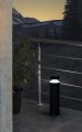Czarna lampa ogrodowa MELZO z cylindryczną obudową i światłem skierowanym w dół wokół górnej części.