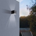 Kinkiet ogrodowy LED DONINNI 1 IP55 w czarnej geometrycznej oprawie, emitujący ciepłe białe światło 3000 K.