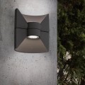 Ciemnoszary kinkiet LED REDONDO z centralnym cylindrycznym modułem świetlnym i rozszerzonymi panelami górnym oraz dolnym.