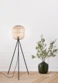 Podłogowa lampa BORDESLEY z jasnym drewnianym kloszem o zaokrąglonych krawędziach i wysoką metalową konstrukcją.