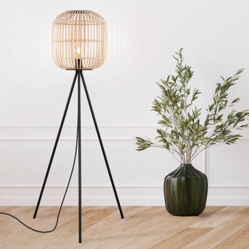 Lampa podłogowa BORDESLEY z ażurowym drewnianym kloszem w naturalnym kolorze i czarną metalową podstawą na trzech nogach.