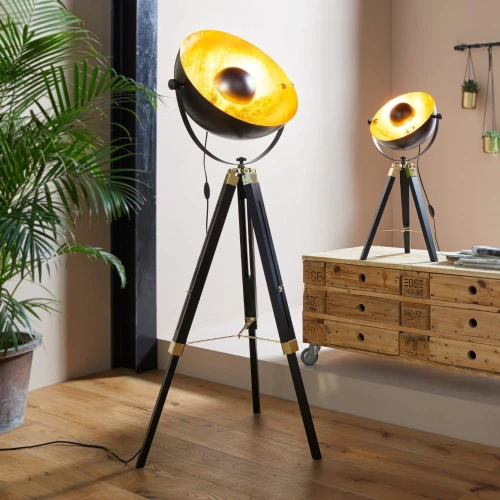Lampa podłogowa COVALEDA z dużym reflektorowym kloszem w kolorze czarnym i złotym oraz trójnożną podstawą.