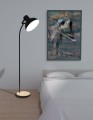 Podłogowa lampa LUBENHAM z regulowanym czarnym kloszem, smukłą metalową konstrukcją i okrągłą podstawą w naturalnym kolorze drewna.