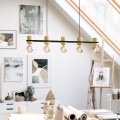 Lampa wisząca CHIEVELEY z długą czarną belką, pięcioma drewnianymi oprawkami i odsłoniętymi żarówkami.