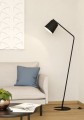 Podłogowa lampa ONEDA z geometryczną metalową konstrukcją, czarnym kloszem z białym środkiem i płaską okrągłą podstawą.