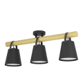 Trzypunktowa lampa sufitowa BOYLE z czarnymi kloszami skierowanymi w dół, osadzonymi na brązowej drewnianej belce.