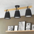 Lampa sufitowa BOYLE z trzema czarnymi metalowymi kloszami i brązową drewnianą belką, zawieszona nad półką z dekoracjami.