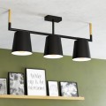Lampa sufitowa LACEY z trzema kremowymi kloszami i czarnymi elementami, zamontowana w jasnym wnętrzu nad półką z dekoracjami.